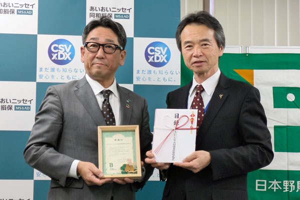 目録と感謝状を手に記念撮影(左から安食執行役員、遠藤理事長)